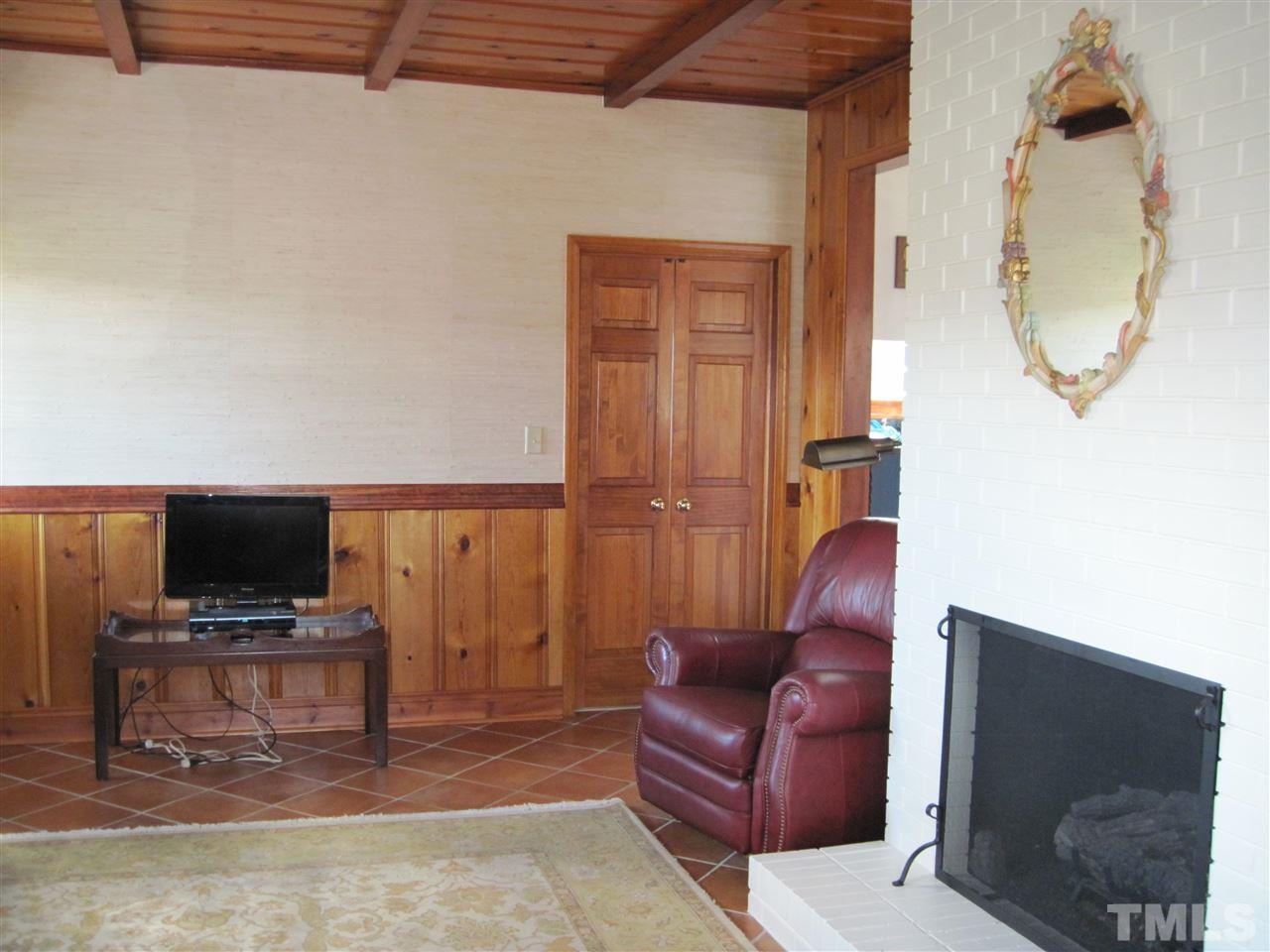 4105 St James Church Road Raleigh, NC 27604 - Photo 3 of 24 a living room with furniture a flat screen tv and a fireplace