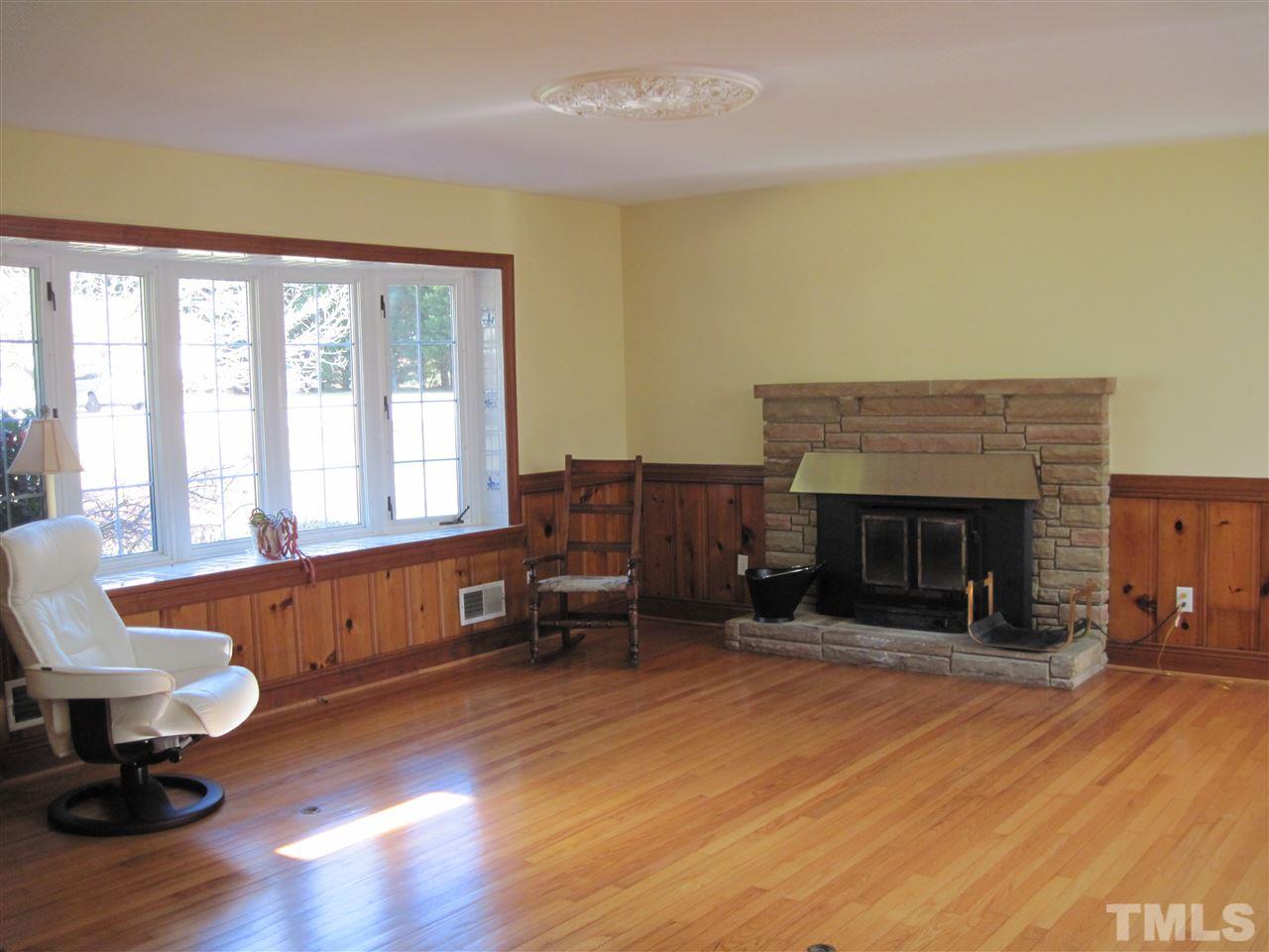 4105 St James Church Road Raleigh, NC 27604 - Photo 5 of 24 a living room with furniture a fireplace and a table