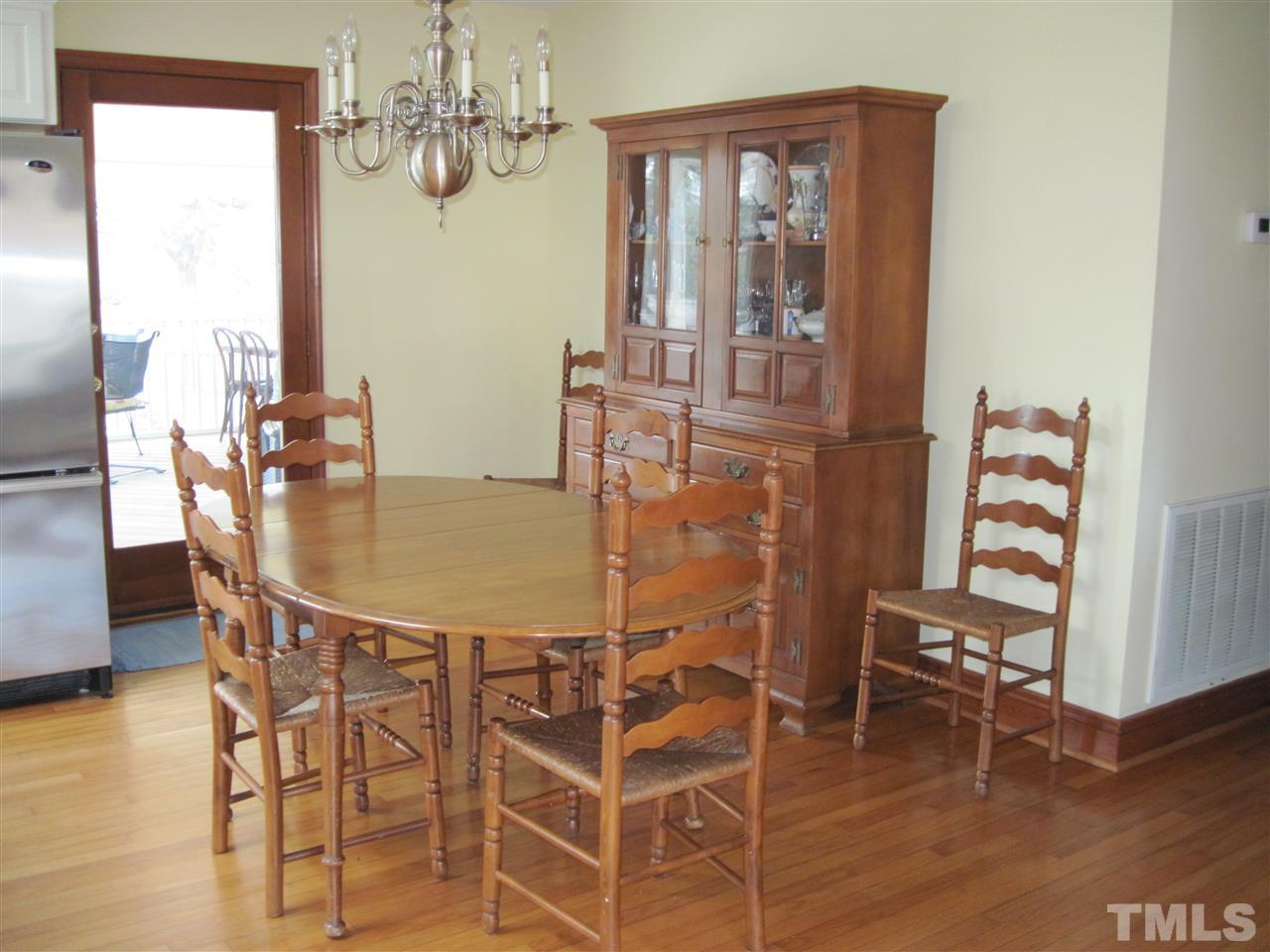 4105 St James Church Road Raleigh, NC 27604 - Photo 7 of 24 a dining room with furniture a chandelier and wooden floor