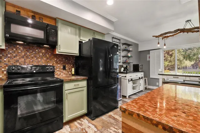 a kitchen with a stove a refrigerator and a microwave