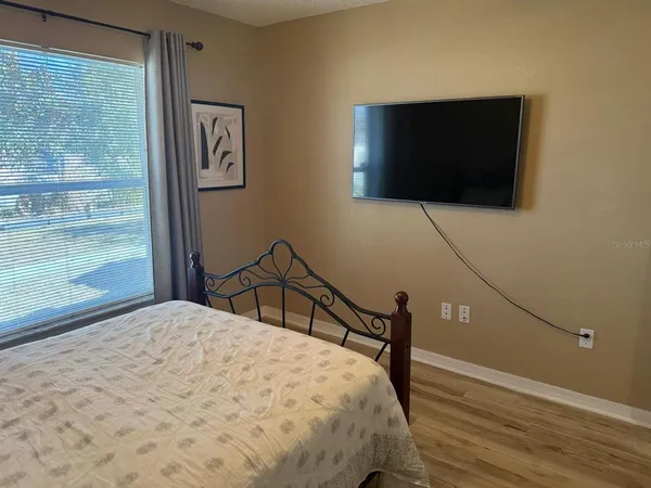 a bedroom with a bed and a flat screen tv
