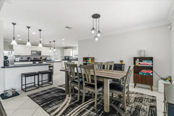 a kitchen with stainless steel appliances a table and chairs in it