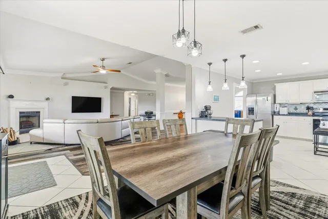 a dining room with wooden floor a chandelier a wooden table and chairs