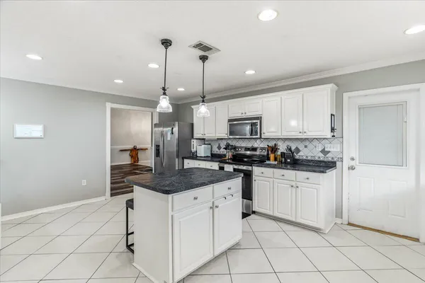 a kitchen with white cabinets appliances and a sink