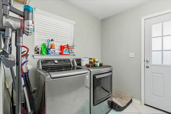 a utility room with dryer washer and a window
