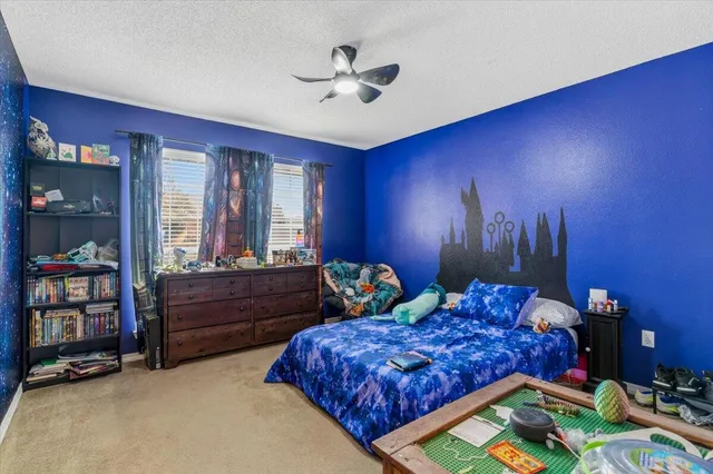 a bed room with a bed and a chandelier fan