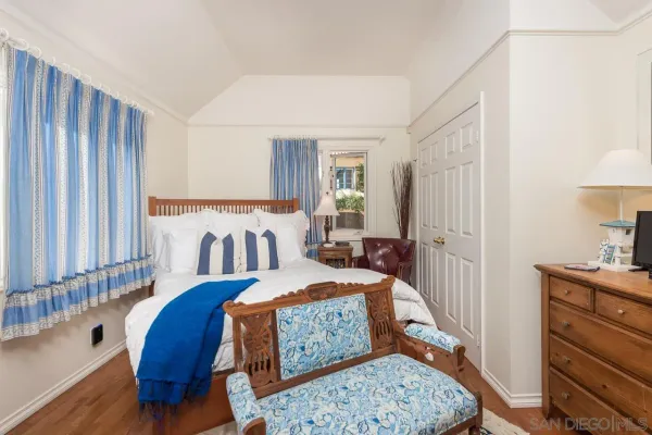 a bedroom with a bed mirror and window