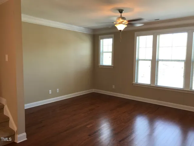 a view of an empty room with wooden floor