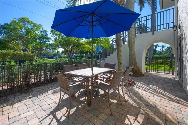 a view of a patio with table and chairs under an umbrella
