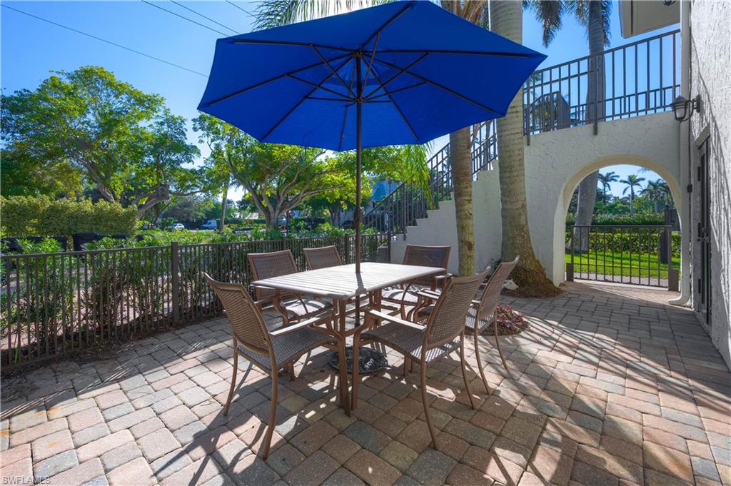 655 8th Avenue South, Unit 3 Naples, FL 34102 - Photo 15 of 48 a view of a patio with table and chairs under an umbrella
