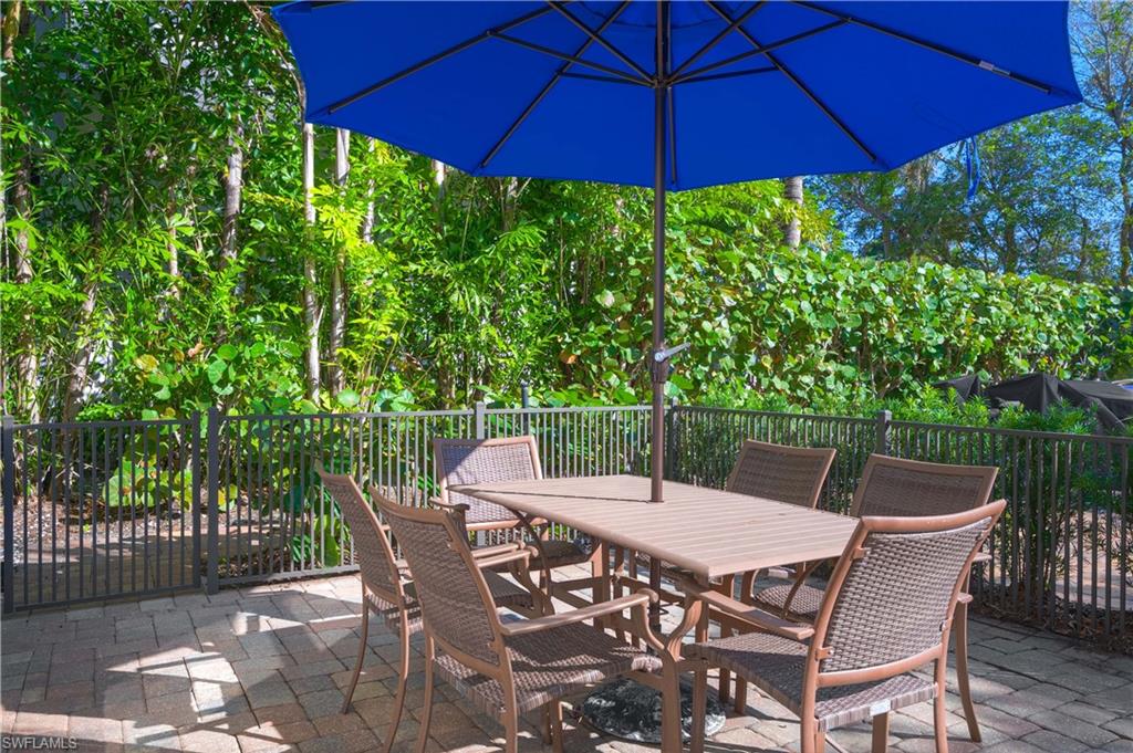 655 8th Avenue South, Unit 3 Naples, FL 34102 - Photo 28 of 48 a view of a patio with table and chairs under an umbrella