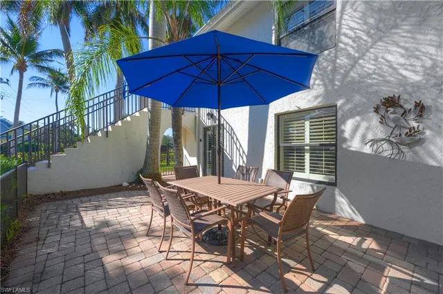 a view of a patio with table and chairs under an umbrella