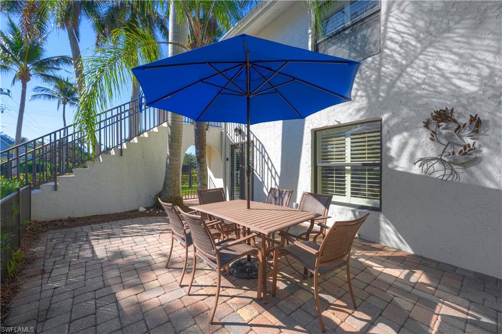 655 8th Avenue South, Unit 3 Naples, FL 34102 - Photo 29 of 48 a view of a patio with table and chairs under an umbrella