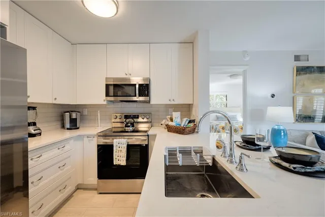 a kitchen with a stove a sink and a white cabinets