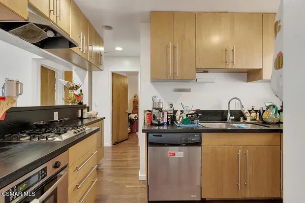 a kitchen with stainless steel appliances granite countertop a sink stove and cabinets