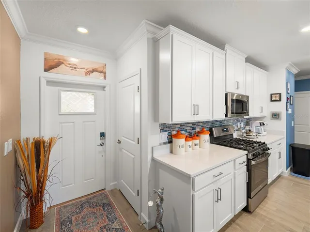 a view of a kitchen with stainless steel appliances wooden floor and a window