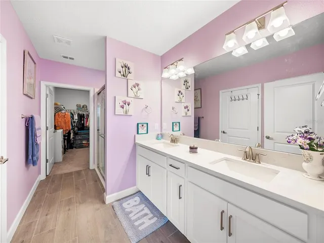 a spacious en suite bathroom with a sink double vanity and a mirror