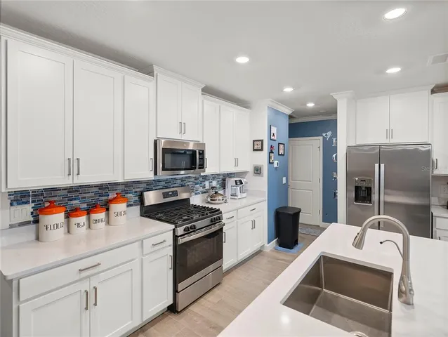 a kitchen with stainless steel appliances granite countertop a refrigerator sink and stove