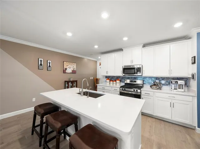 a kitchen with stainless steel appliances kitchen island granite countertop a dining table and chairs