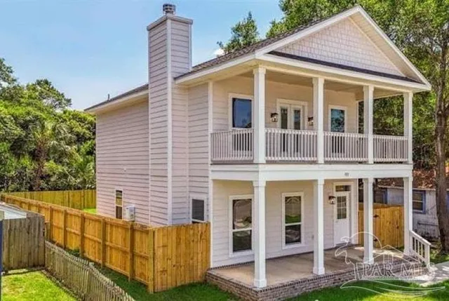 a view of house with a yard and wooden fence