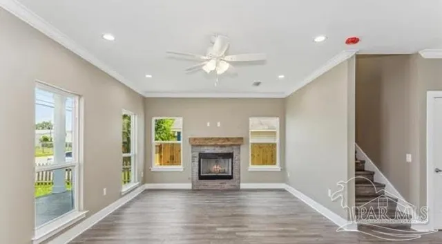 an empty room with wooden floor fireplace and windows