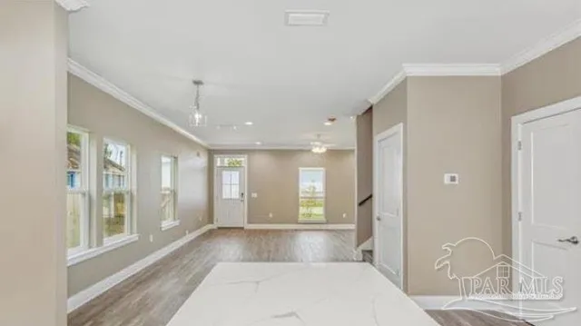 a view of an entryway of a house and a livingroom with furniture