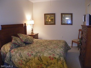 3780 Sawgrass Way, Unit 3346 Naples, FL 34112 - Photo 6 of 8 a bedroom with a bed and wooden floor