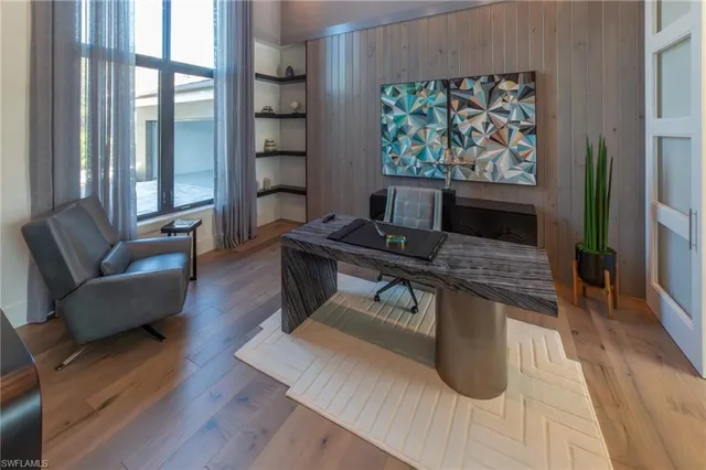 a living room with furniture a large window and wooden floor