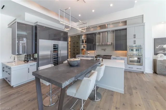 a kitchen with a table chairs refrigerator and cabinets