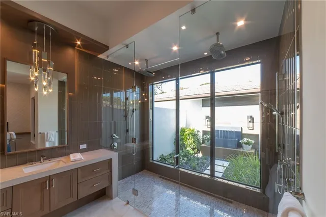 a bathroom with a large mirror vanity and a shower