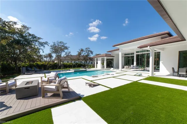 a view of a house with swimming pool and sitting area