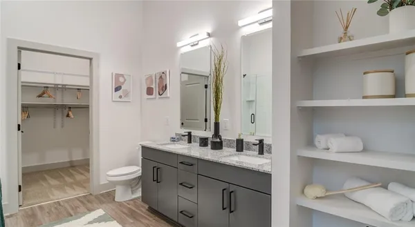 a bathroom with a granite countertop sink a toilet and a shower
