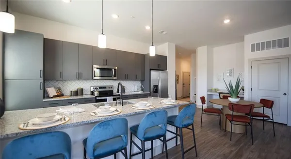 a kitchen with granite countertop a dining table and chairs