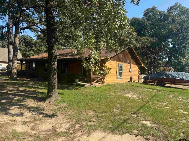 a view of a house with backyard and tree