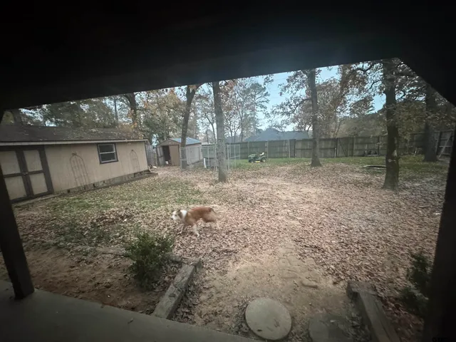 a backyard of a house with large trees and brick walls