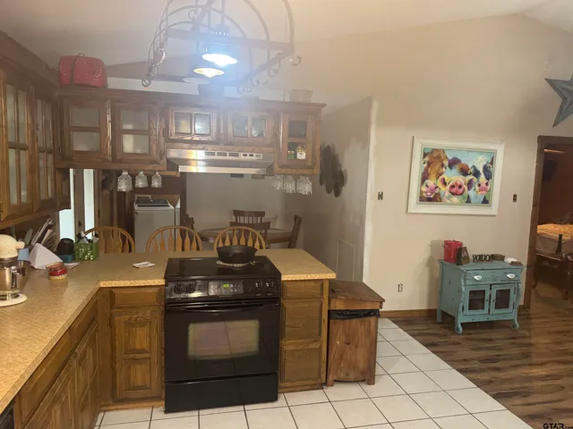 a kitchen with granite countertop a stove top oven and cabinets