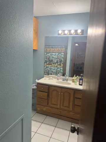 a bathroom with a granite countertop sink and a mirror