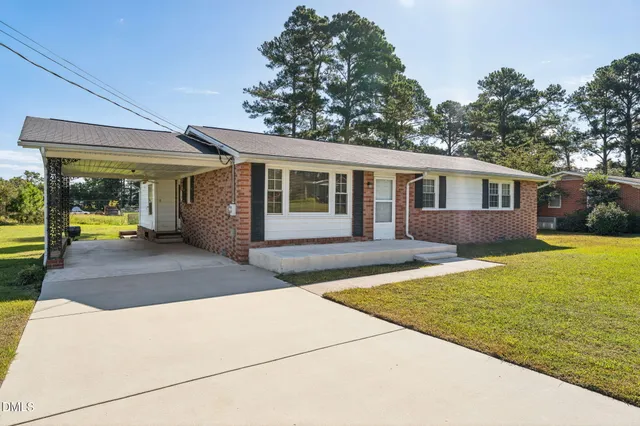 a view of a house with backyard and sitting area