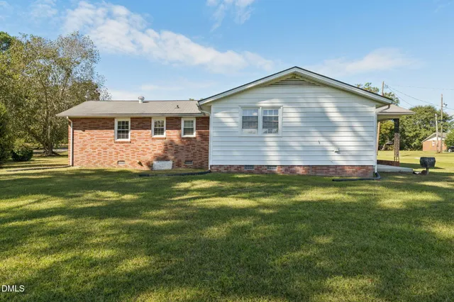 a front view of house with yard and trees in the background