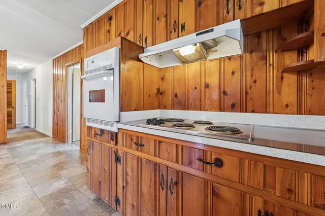 a utility room with stainless steel appliances a stove a sink and a refrigerator