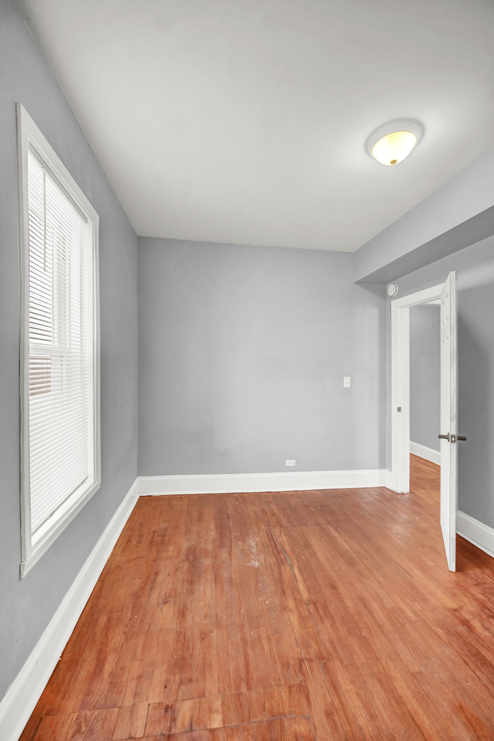 1 East 114th Street Chicago, IL 60628 - Photo 11 of 25 a view of an empty room with wooden floor and a window