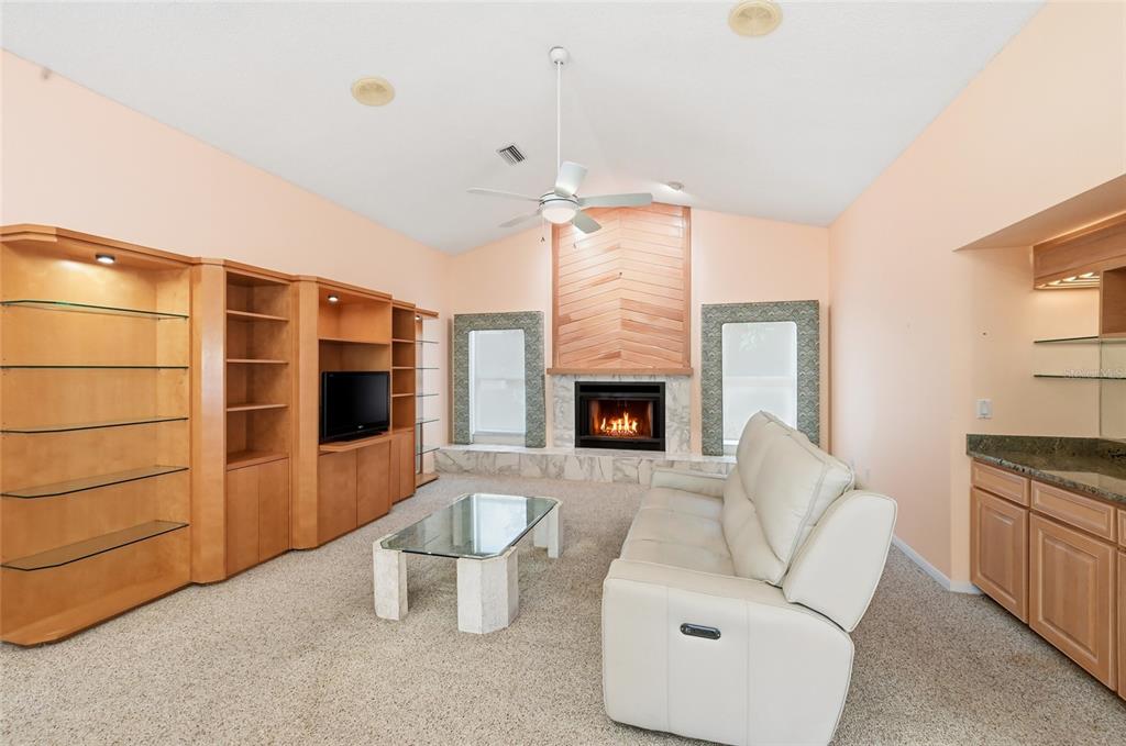 3732 Surrey Lane Sarasota, FL 34235 - Photo 13 of 35 a living room with furniture a fireplace and a flat screen tv