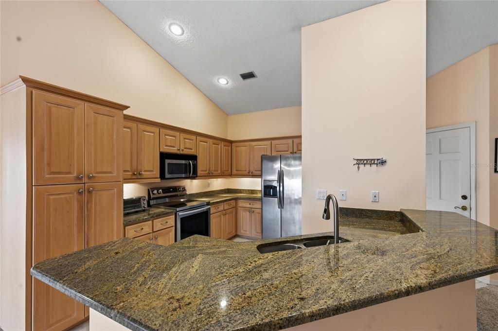 3732 Surrey Lane Sarasota, FL 34235 - Photo 17 of 35 a kitchen with a center island and stainless steel appliances