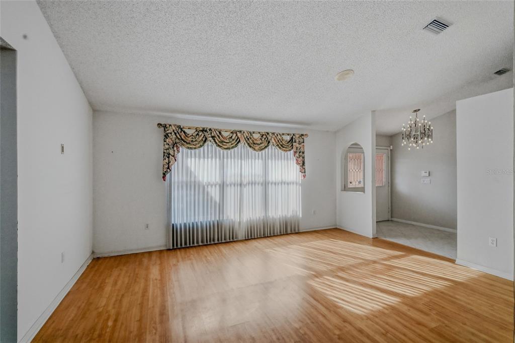 3732 Surrey Lane Sarasota, FL 34235 - Photo 9 of 35 a view of an empty room with wooden floor and a window