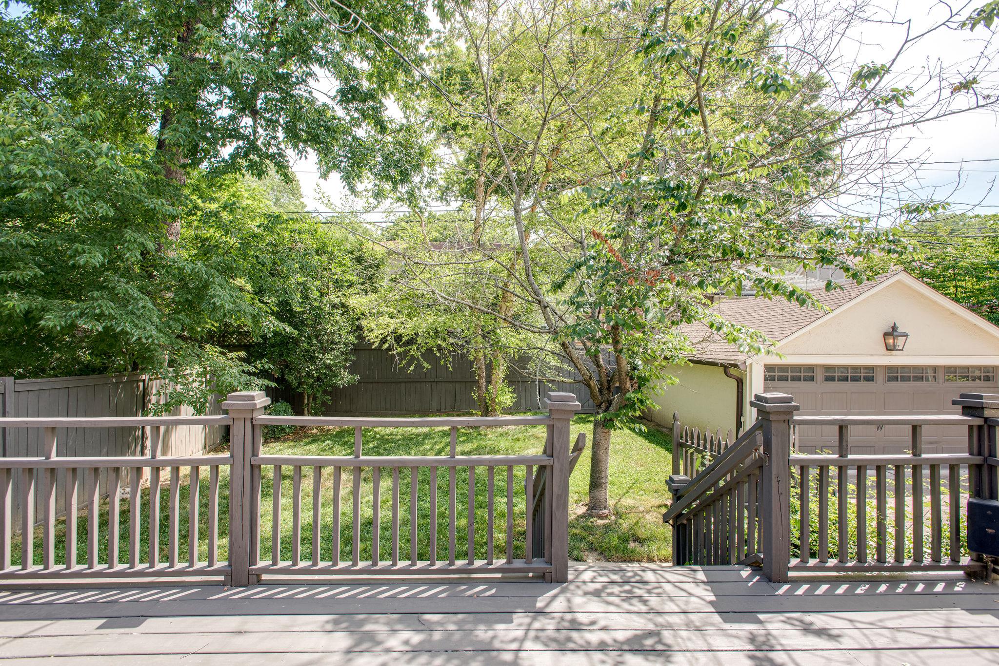 232 Cherokee Road Nashville, TN 37205 - Photo 22 of 24 a view of a brick house next to a yard with large trees