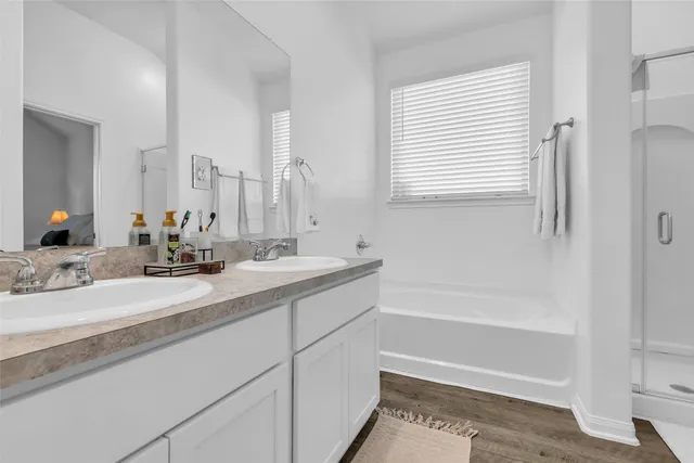 a bathroom with a bathtub a sink and a window