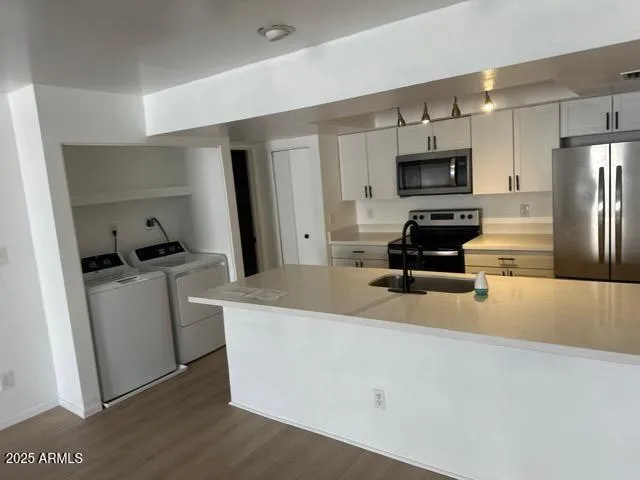 a kitchen with stainless steel appliances a stove a sink a refrigerator a window