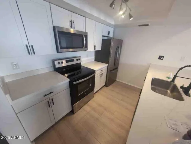 a kitchen with a sink and steel appliances