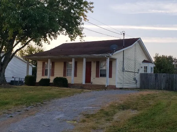 a view of a yard in front of a house with large tree