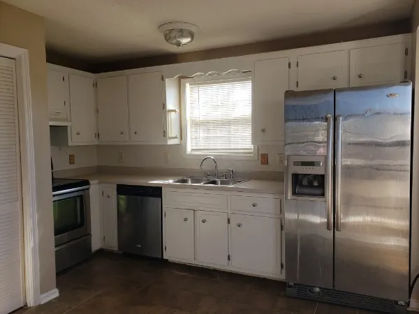 a kitchen with a refrigerator sink and cabinets